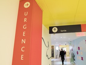 A corridor in a hospital shows two signs, one saying URGENCE, the other SORTIE